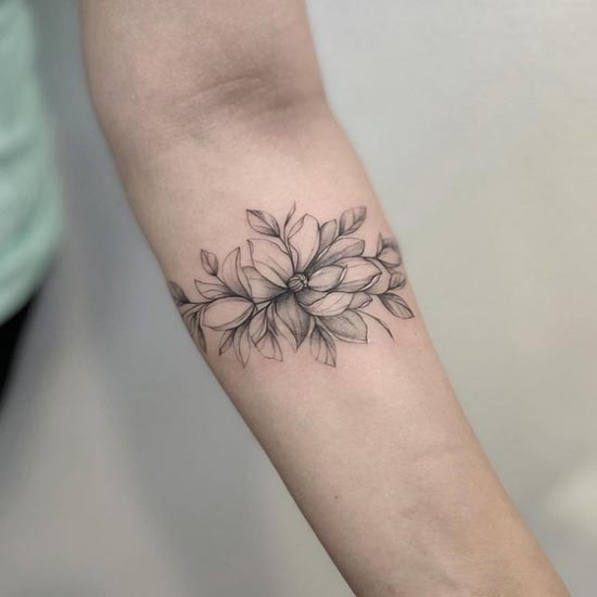 magnolia flower botanical leaves armband tattoo fine line female upper forearm